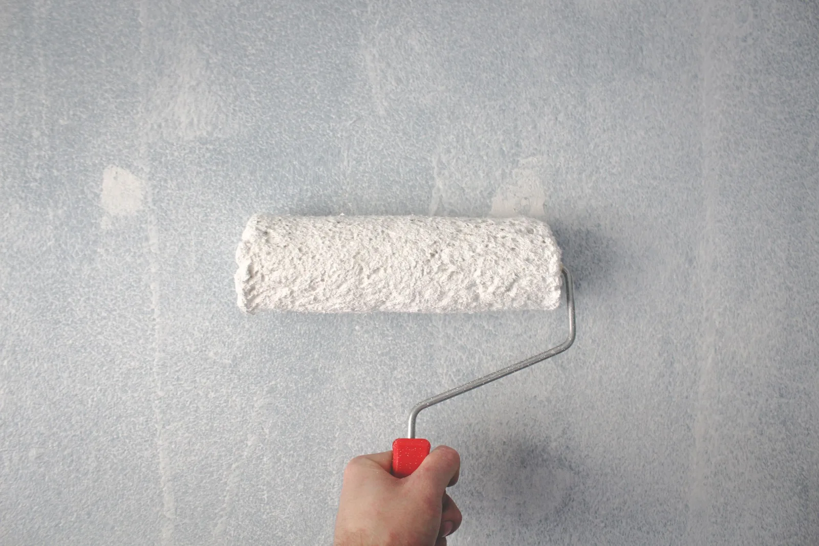 Application de peinture au rouleau sur un mur en parpaings